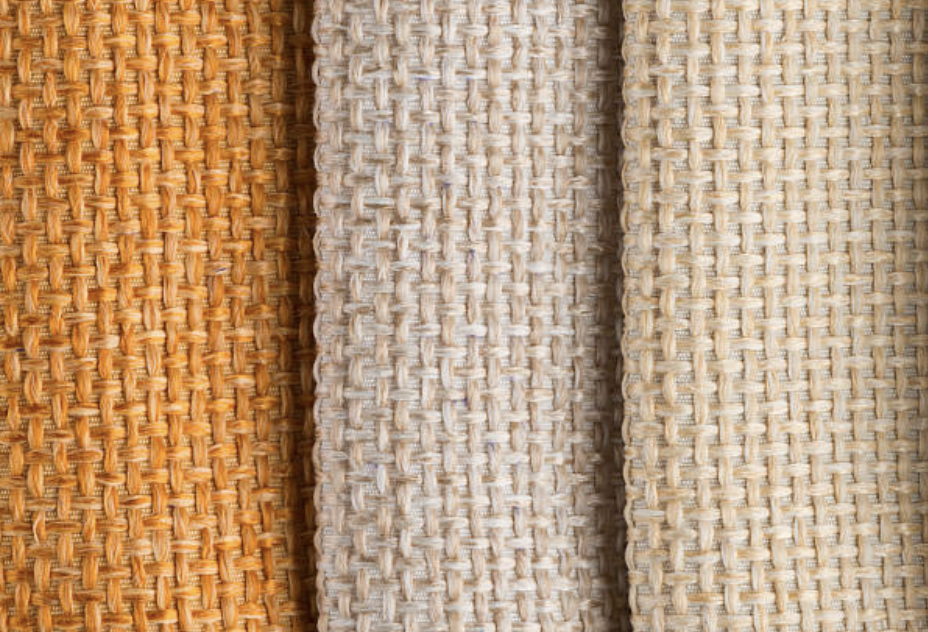 Multi-shade natural jute cloths displayed in rolls with varied texture and thickness.